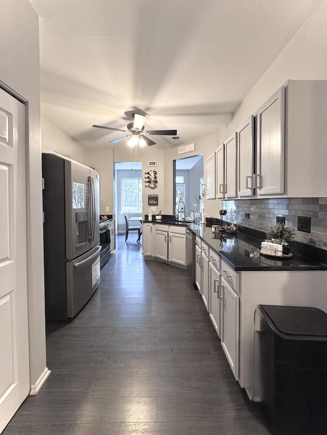 3125 Anton Dr Unit 3125, Aurora, IL 60504 - kitchen with stainless steel appliances, dark countertops, a ceiling fan, dark wood finished floors, and a peninsula