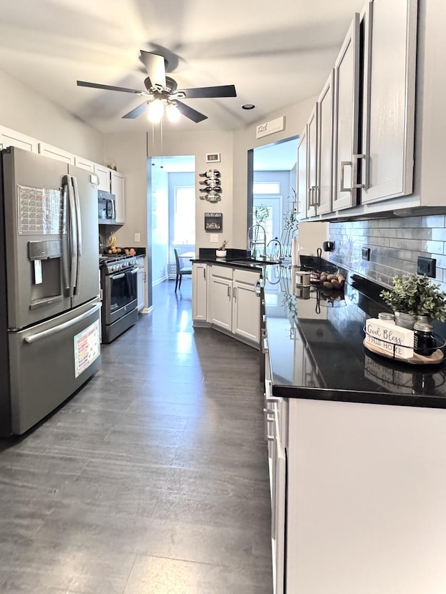 3125 Anton Dr Unit 3125, Aurora, IL 60504 - kitchen with appliances with stainless steel finishes, a ceiling fan, a peninsula, tasteful backsplash, and dark countertops
