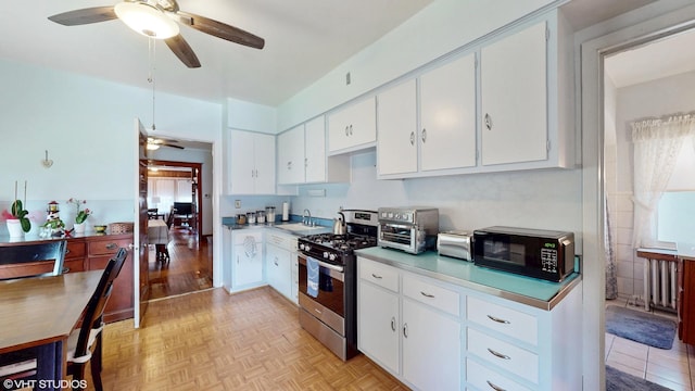 442 Hannah Ave, Forest Park, IL 60130 - kitchen with stainless steel gas range oven, ceiling fan, black microwave, and white cabinets