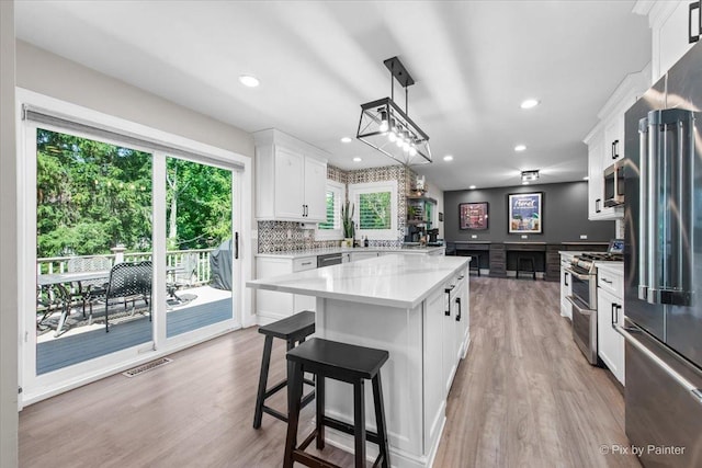 746 Parker Ct, Geneva, IL 60134 - kitchen with appliances with stainless steel finishes, light countertops, a center island, light wood-type flooring, and white cabinetry