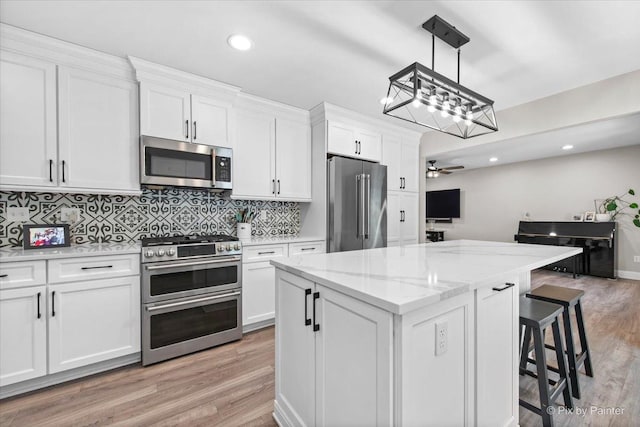 746 Parker Ct, Geneva, IL 60134 - kitchen featuring appliances with stainless steel finishes, white cabinets, light wood-type flooring, a center island, and recessed lighting