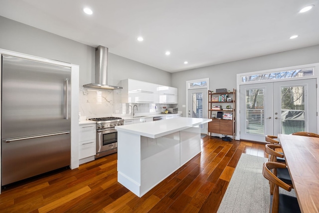 1123 W 19th St, Chicago, IL 60608 - kitchen featuring premium appliances, wall chimney range hood, modern cabinets, white cabinetry, and light countertops