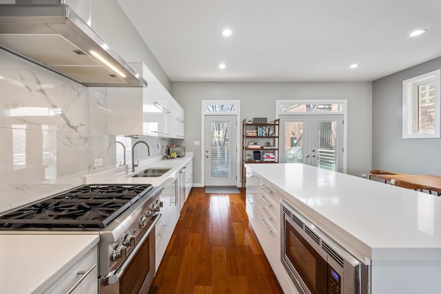 1123 W 19th St, Chicago, IL 60608 - kitchen with stainless steel appliances, range hood, light countertops, white cabinetry, and recessed lighting