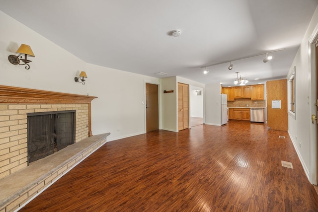 808 S Cedarcrest Dr, Schaumburg, IL 60193 - unfurnished living room featuring a chandelier, dark wood finished floors, a brick fireplace, and rail lighting