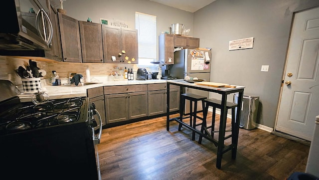 7250 S Morgan St, Chicago, IL 60621 - kitchen with gas stove, stainless steel microwave, dark wood-style flooring, light countertops, and backsplash