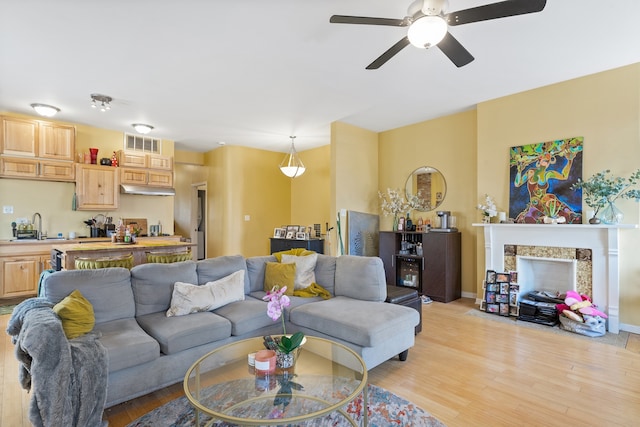 4424 S University Ave, Chicago, IL 60653 - living area featuring light wood finished floors, a ceiling fan, and a high end fireplace