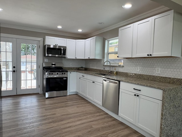 5101 W 1000 N Rd, Kankakee, IL 60901 - kitchen with appliances with stainless steel finishes, white cabinetry, ornamental molding, decorative backsplash, and wood finished floors