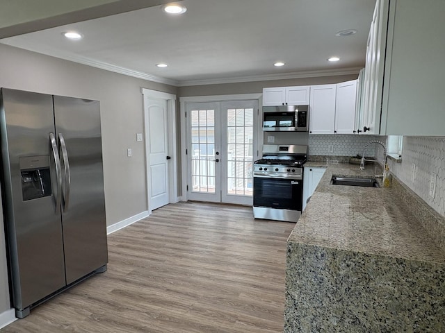 5101 W 1000 N Rd, Kankakee, IL 60901 - kitchen with appliances with stainless steel finishes, crown molding, light wood-style flooring, tasteful backsplash, and white cabinets