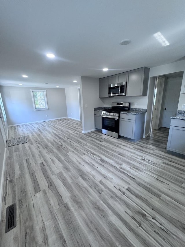 5101 W 1000 N Rd, Kankakee, IL 60901 - kitchen featuring appliances with stainless steel finishes, gray cabinets, light wood-style flooring, open floor plan, and recessed lighting