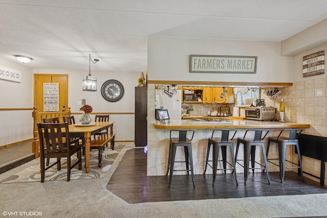 5204 Midlothian Unit 214, Crestwood, IL 60418 - kitchen with black microwave, decorative backsplash, a peninsula, and a chandelier