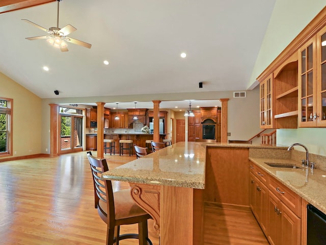 9804 Palmer Dr, Lakewood, IL 60014 - kitchen featuring ornate columns, a breakfast bar, recessed lighting, glass insert cabinets, and high vaulted ceiling