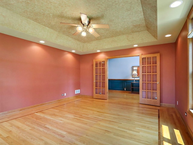 9804 Palmer Dr, Lakewood, IL 60014 - empty room featuring a raised ceiling, french doors, light wood-type flooring, and recessed lighting