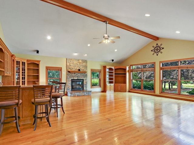 9804 Palmer Dr, Lakewood, IL 60014 - living area with beam ceiling, light wood-style flooring, a ceiling fan, a stone fireplace, and high vaulted ceiling