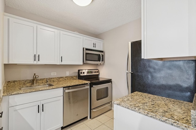 30 E Huron St Unit 2108, Chicago, IL 60611 - kitchen featuring appliances with stainless steel finishes, white cabinetry, a textured ceiling, light tile patterned floors, and light stone countertops