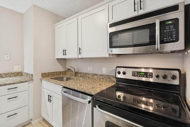 30 E Huron St Unit 2108, Chicago, IL 60611 - kitchen with appliances with stainless steel finishes, light stone countertops, white cabinets, and light tile patterned floors