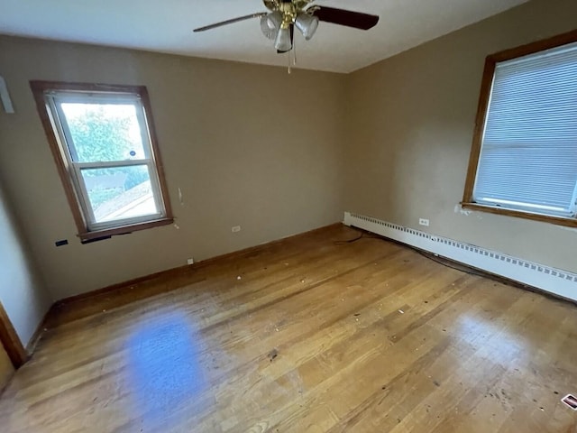 2020 W 53rd Pl, Chicago, IL 60609 - spare room featuring a baseboard radiator, light wood-style floors, and ceiling fan