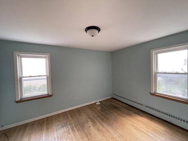 2020 W 53rd Pl, Chicago, IL 60609 - spare room featuring a baseboard radiator, plenty of natural light, and wood finished floors