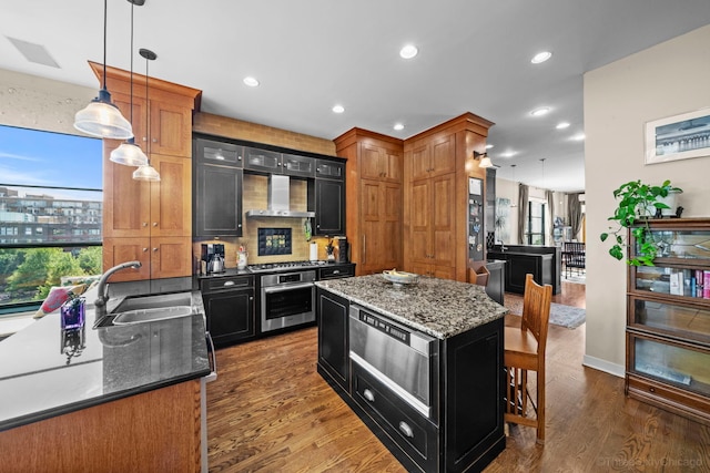 849 W Monroe St Unit Ph5, Chicago, IL 60607 - kitchen with wall chimney range hood, stainless steel appliances, dark cabinets, dark wood-type flooring, and hanging light fixtures