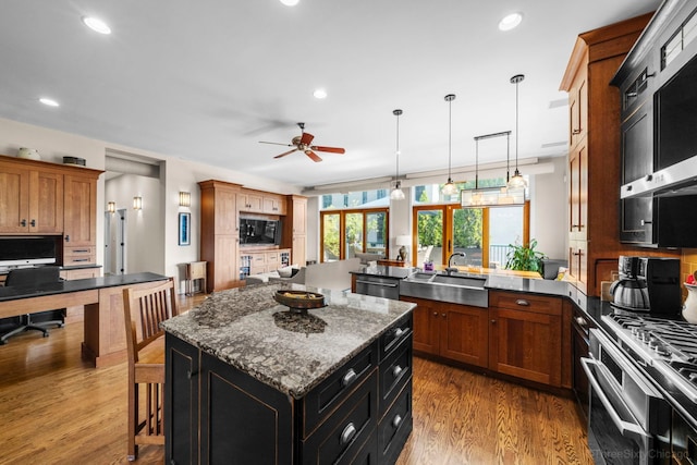 849 W Monroe St Unit Ph5, Chicago, IL 60607 - kitchen with stainless steel appliances, a ceiling fan, pendant lighting, a peninsula, and a breakfast bar area