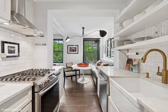 1255 N State Pkwy Unit 3D, Chicago, IL 60610 - kitchen with wall chimney range hood, stainless steel appliances, open shelves, tasteful backsplash, and dark wood-style floors