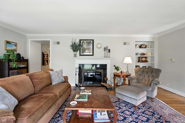 2907 Orchard Ave, Wilmette, IL 60091 - living room with crown molding, wood finished floors, a high end fireplace, and built in shelves
