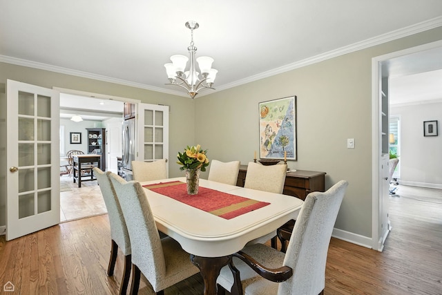 2907 Orchard Ave, Wilmette, IL 60091 - dining area with ornamental molding, a chandelier, light wood-style floors, and french doors
