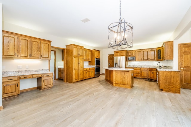 771 E Hickory Ave, Addison, IL 60101 - kitchen with stainless steel appliances, brown cabinets, a chandelier, light wood-type flooring, and a kitchen island