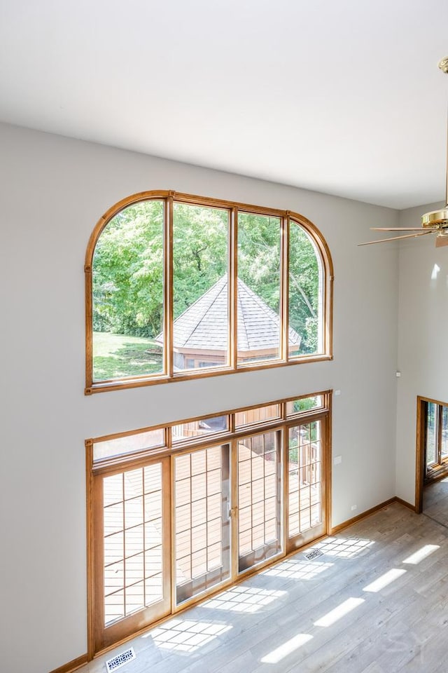 771 E Hickory Ave, Addison, IL 60101 - unfurnished living room with a ceiling fan, wood finished floors, and a high ceiling