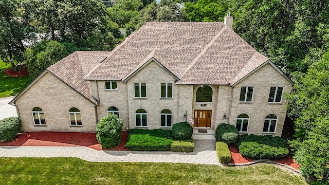 771 E Hickory Ave, Addison, IL 60101 - french country inspired facade featuring a chimney, a front lawn, a shingled roof, and brick siding