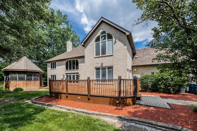 771 E Hickory Ave, Addison, IL 60101 - rear view of property featuring a chimney, a sunroom, a wooden deck, brick siding, and a yard
