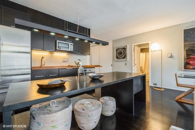 880 N Lake Shore Dr Unit 6F, Chicago, IL 60611 - kitchen featuring appliances with stainless steel finishes, modern cabinets, dark countertops, a kitchen breakfast bar, and wood finished floors