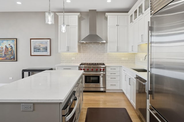 4115 N Lincoln Ave Unit 4N, Chicago, IL 60618 - kitchen with premium appliances, wall chimney range hood, recessed lighting, a kitchen island, and backsplash
