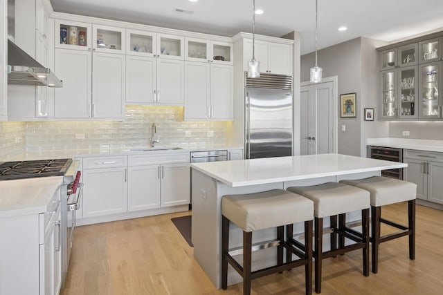 4115 N Lincoln Ave Unit 4N, Chicago, IL 60618 - kitchen featuring high quality appliances, beverage cooler, light wood finished floors, a breakfast bar area, and recessed lighting