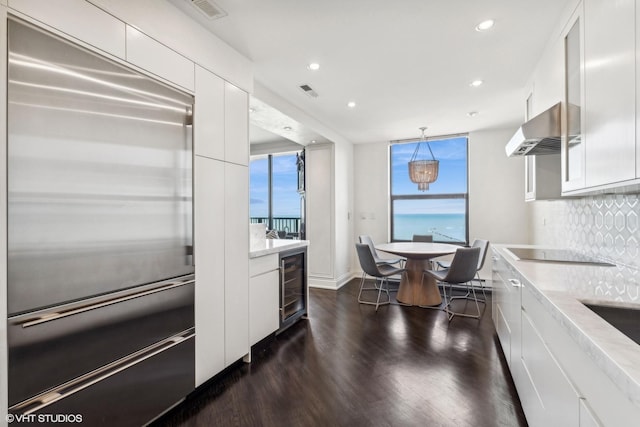 1040 N Lake Shore Dr Unit 26B, Chicago, IL 60611 - kitchen with stainless steel built in fridge, wine cooler, exhaust hood, white cabinetry, and black electric cooktop