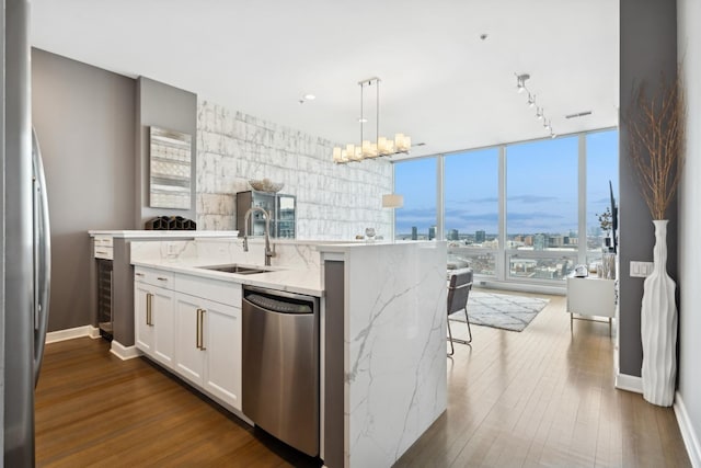 500 W Superior St Unit 1504, Chicago, IL 60654 - kitchen featuring appliances with stainless steel finishes, a view of city, white cabinetry, dark wood finished floors, and pendant lighting