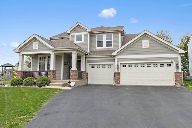 244 Prescott Ave, Elgin, IL 60124 - view of front of house featuring driveway, brick siding, covered porch, and a shingled roof