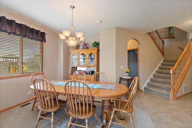 244 Prescott Ave, Elgin, IL 60124 - dining space featuring a chandelier, stairway, arched walkways, and light tile patterned floors