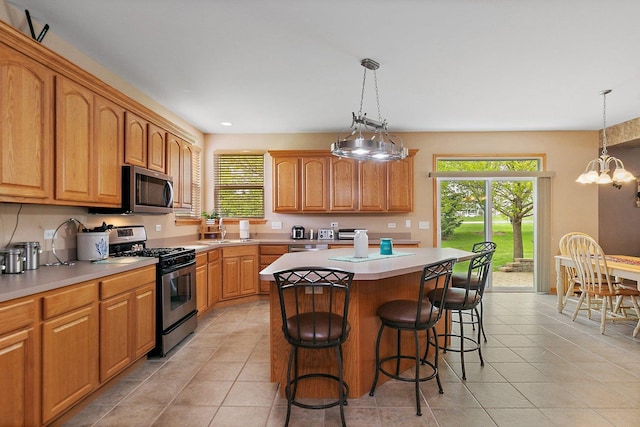 244 Prescott Ave, Elgin, IL 60124 - kitchen with stainless steel appliances, light tile patterned flooring, a kitchen island, plenty of natural light, and recessed lighting