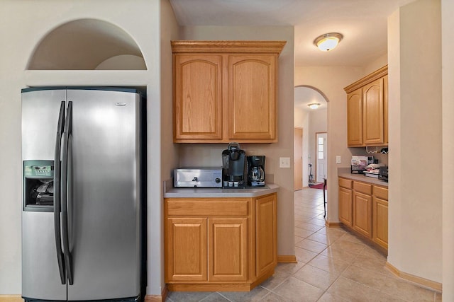 244 Prescott Ave, Elgin, IL 60124 - kitchen featuring stainless steel fridge with ice dispenser, light tile patterned floors, light countertops, and arched walkways