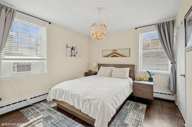 2427 W Farragut Ave Unit 1A, Chicago, IL 60625 - bedroom with a baseboard heating unit, dark wood-style flooring, a chandelier, and multiple windows