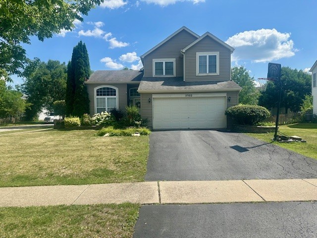 5302 Foxwood Ct, Plainfield, IL 60586 - split level home featuring asphalt driveway, a front lawn, and an attached garage