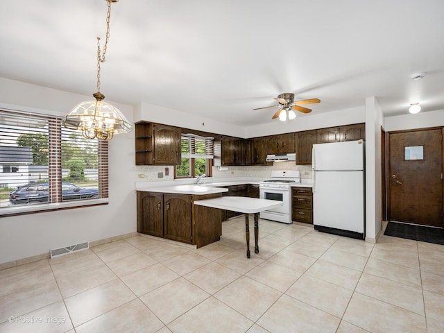 628 W 15th St, Chicago Heights, IL 60411 - kitchen featuring white appliances, dark brown cabinetry, a peninsula, under cabinet range hood, and light countertops