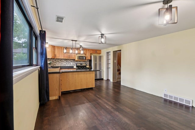 924 E 159th Pl, South Holland, IL 60473 - kitchen featuring stainless steel appliances, dark countertops, dark wood finished floors, decorative light fixtures, and tasteful backsplash