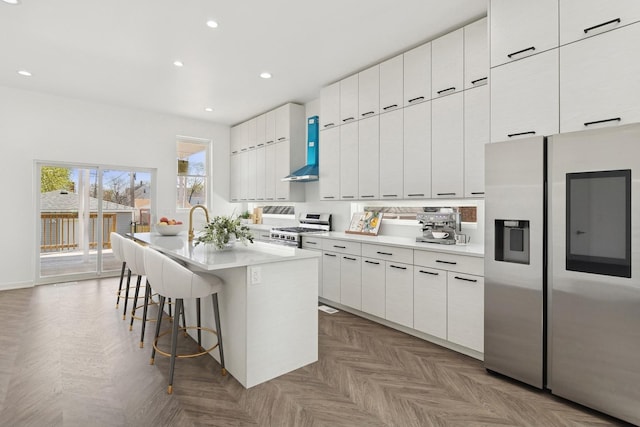 1537 Scoville Ave, Berwyn, IL 60402 - kitchen featuring stainless steel appliances, a breakfast bar area, white cabinetry, an island with sink, and light countertops