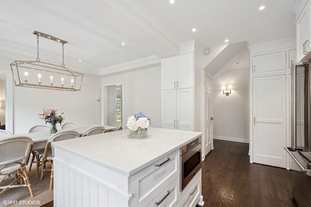 2735 Simpson St, Evanston, IL 60201 - kitchen featuring stainless steel microwave, white cabinetry, recessed lighting, dark wood-type flooring, and a kitchen island