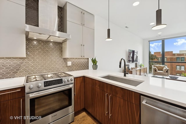 2125 N Mozart St Unit 3, Chicago, IL 60647 - kitchen featuring appliances with stainless steel finishes, wall chimney exhaust hood, light countertops, and recessed lighting
