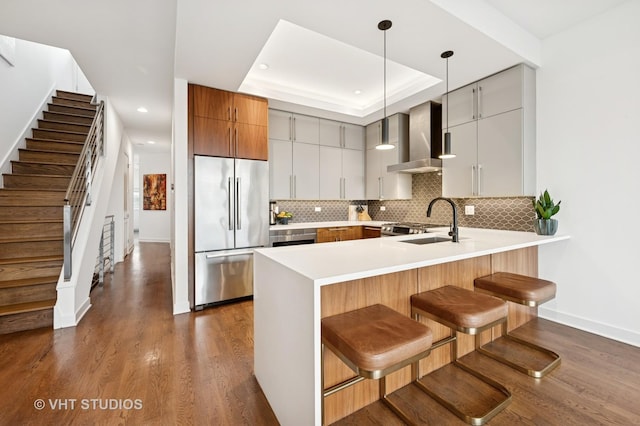 2125 N Mozart St Unit 3, Chicago, IL 60647 - kitchen featuring stainless steel fridge, wall chimney exhaust hood, a peninsula, tasteful backsplash, and dark wood-type flooring