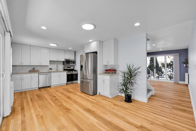 8852 Robin Dr Unit E, Des Plaines, IL 60016 - kitchen featuring stainless steel appliances, decorative backsplash, light wood-style floors, white cabinets, and recessed lighting