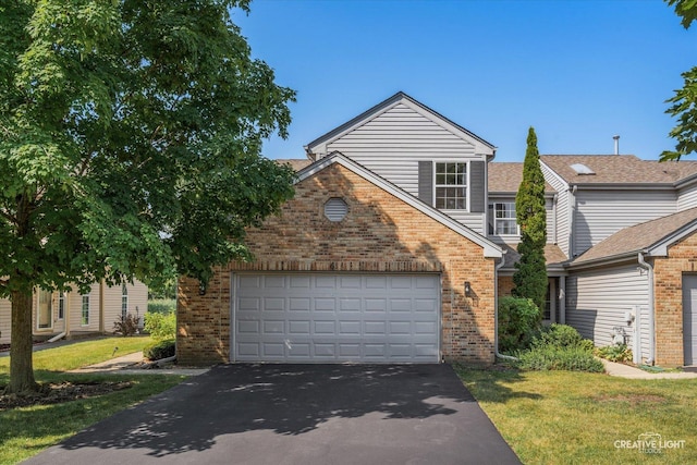 61 King Dr, Streamwood, IL 60107 - view of front facade featuring asphalt driveway, brick siding, and a front lawn