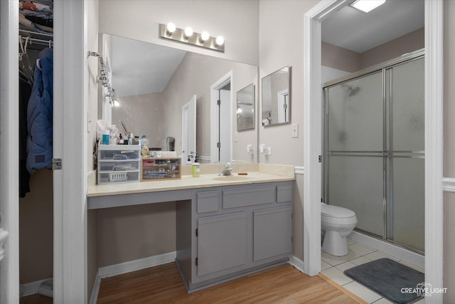 61 King Dr, Streamwood, IL 60107 - bathroom featuring vanity, a stall shower, a walk in closet, and wood finished floors